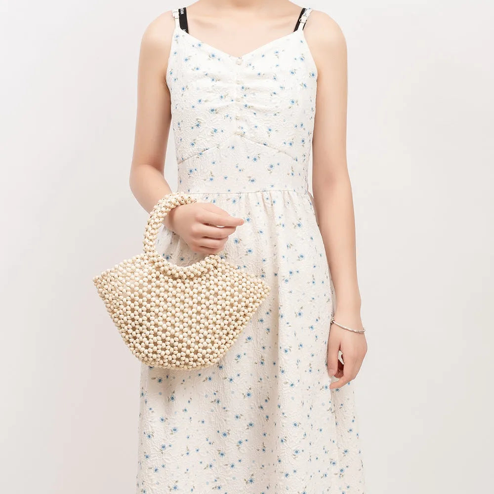Hand-woven maple wooden bead beach bag in dumpling shape with hollow weave design