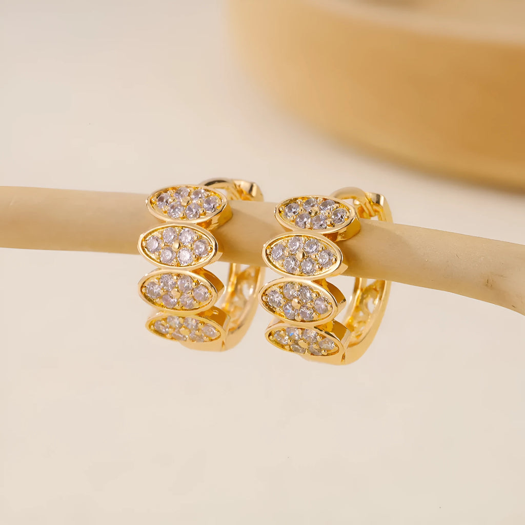 Gold-coloured women's earrings with zircon stones in zirconium and copper construction