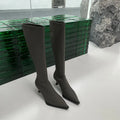 Women's black pointed toe below knee stiletto heel boots with a back zipper on display.