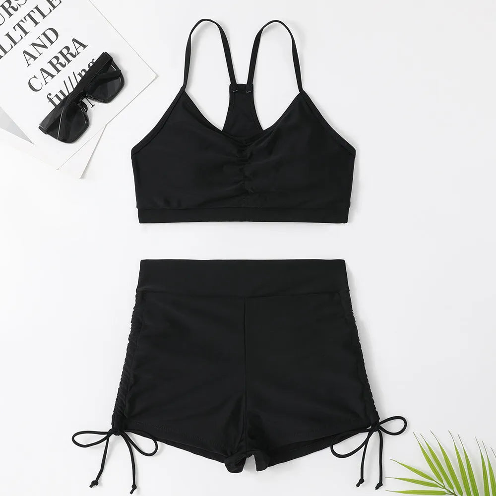 Women's black or purple high-waist split bikini swimsuit with sleeveless top and shorts.