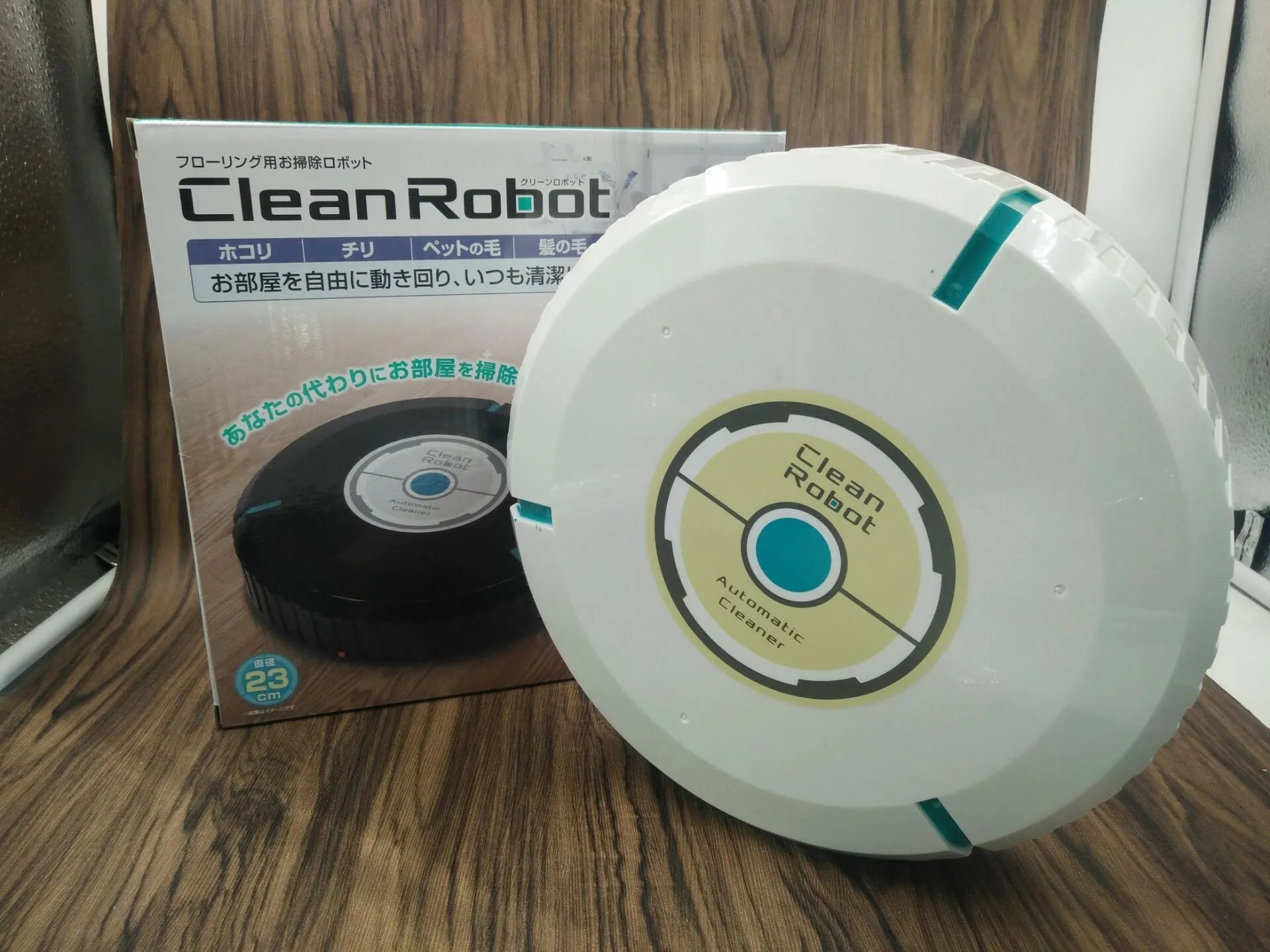 Black automatic robot vacuum cleaner on a wooden floor
