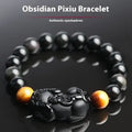 Mexico gold sheen obsidian Pi Xiu bracelet in unisex ethnic style on a wrist.