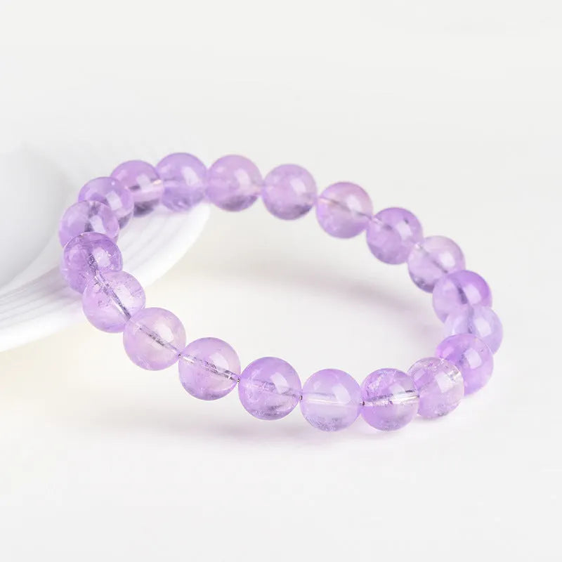 Lavender round amethyst crystal bead bracelet with water ripple design on a wrist.