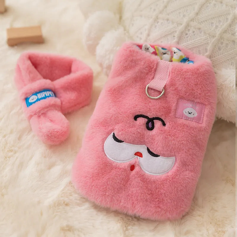 Small dog wearing a pink cartoon bear hoodie with matching detachable scarf, standing indoors