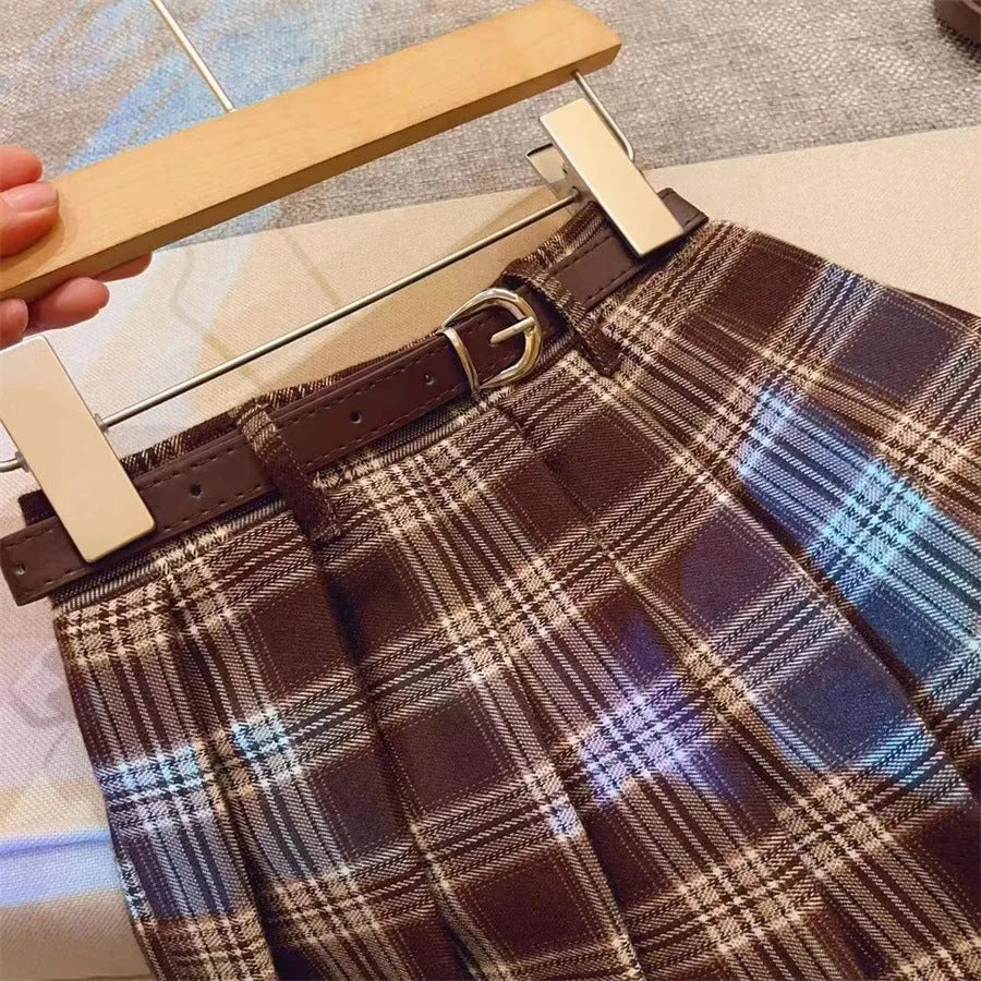 Girls cotton plaid pleated A-line skirt on a hanger, showing its length and pattern.