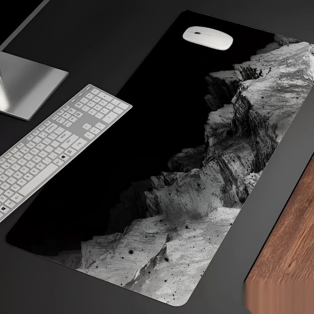Oversized natural rubber mouse pad with printed graphic and integrated wrist support on a desk.