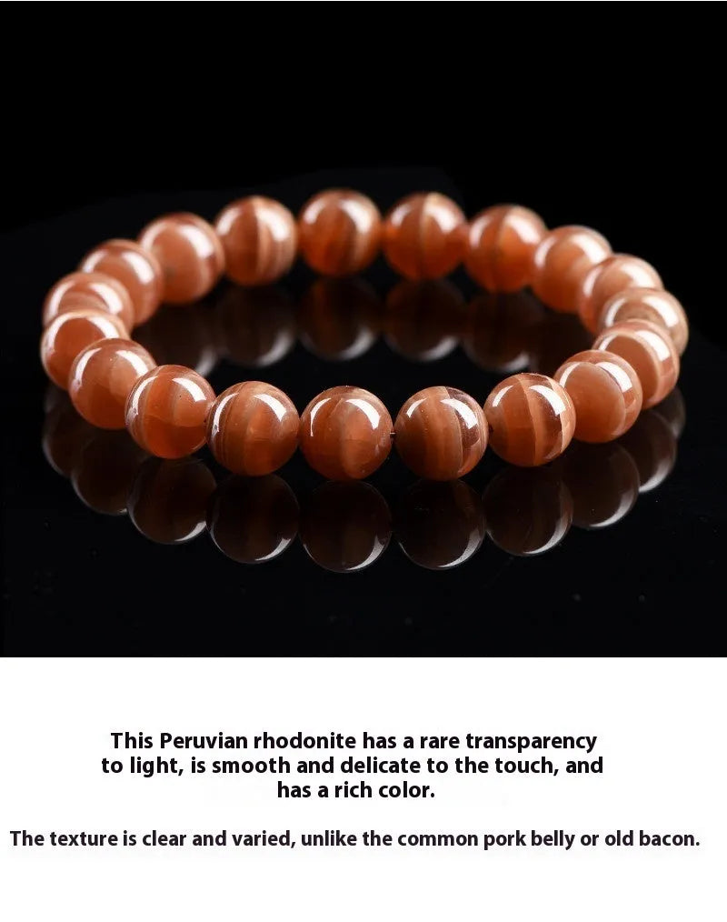 Natural old mine rhodochrosite round bead bracelet with geometric and Ruyi design on a wrist.