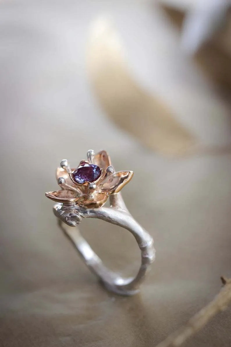 A two-tone silver women's ring with a geometric band and a floral ornament.