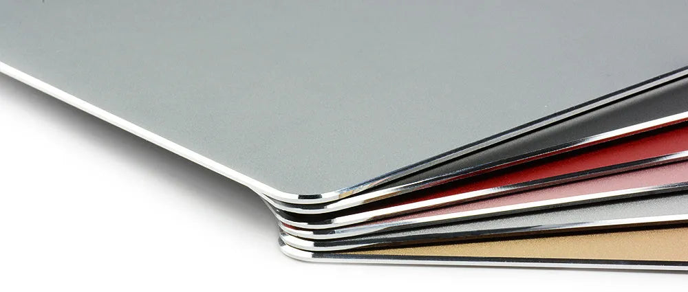 Black aluminium alloy double-sided mouse pad on a desk with a computer mouse on top