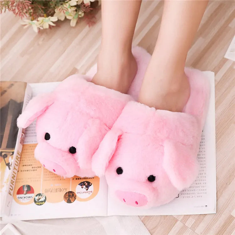 Pink pig-shaped plush indoor slippers with a cute animal face design, shown on a plain background.