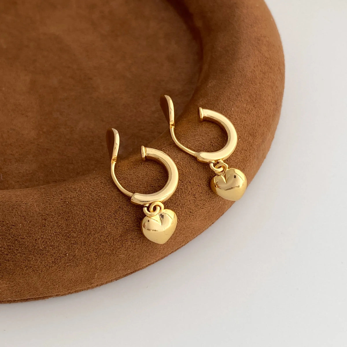 Copper heart-shaped earrings in gold and silver electroplate, available as ear clips or studs for women