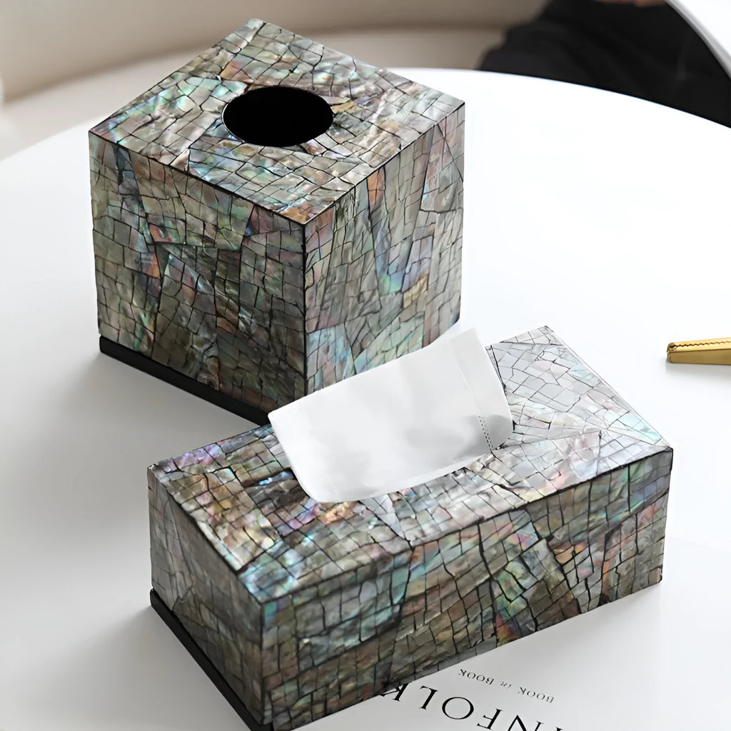 A black square natural shell storage box with a removable white internal organiser on a wooden table.