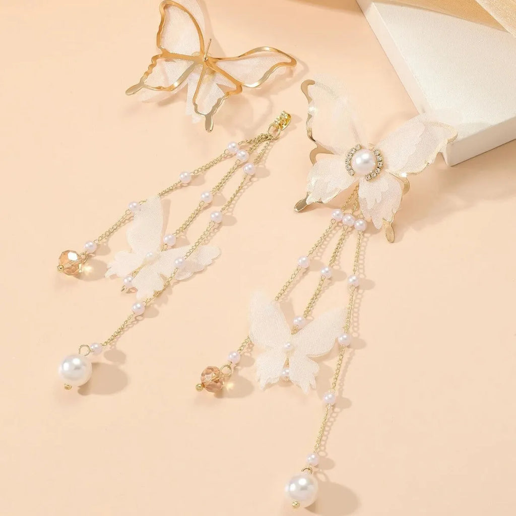 A pair of white butterfly-shaped earrings with tassel lace, pearls, and clear rhinestones on a copper alloy base.