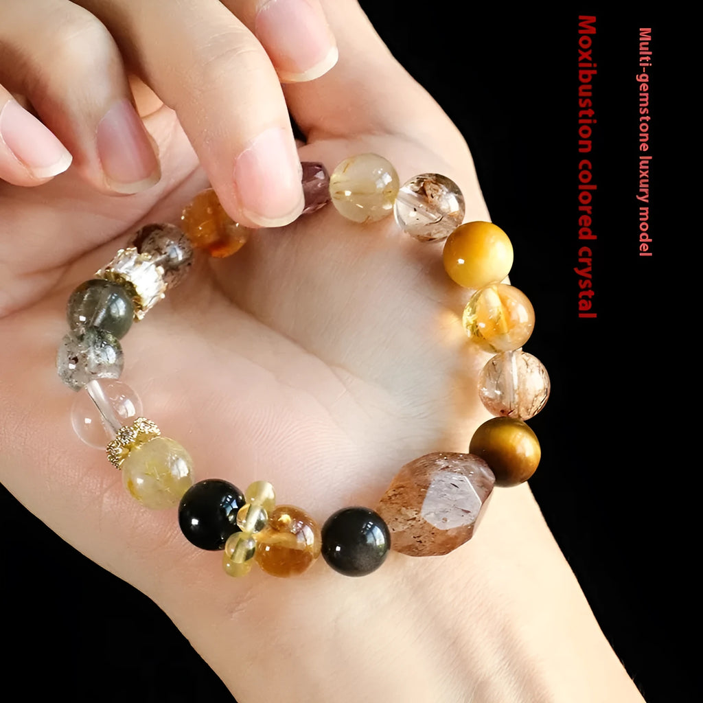 Close-up of a women's black and gold bracelet with natural Super Seven Duobao crystal beads.