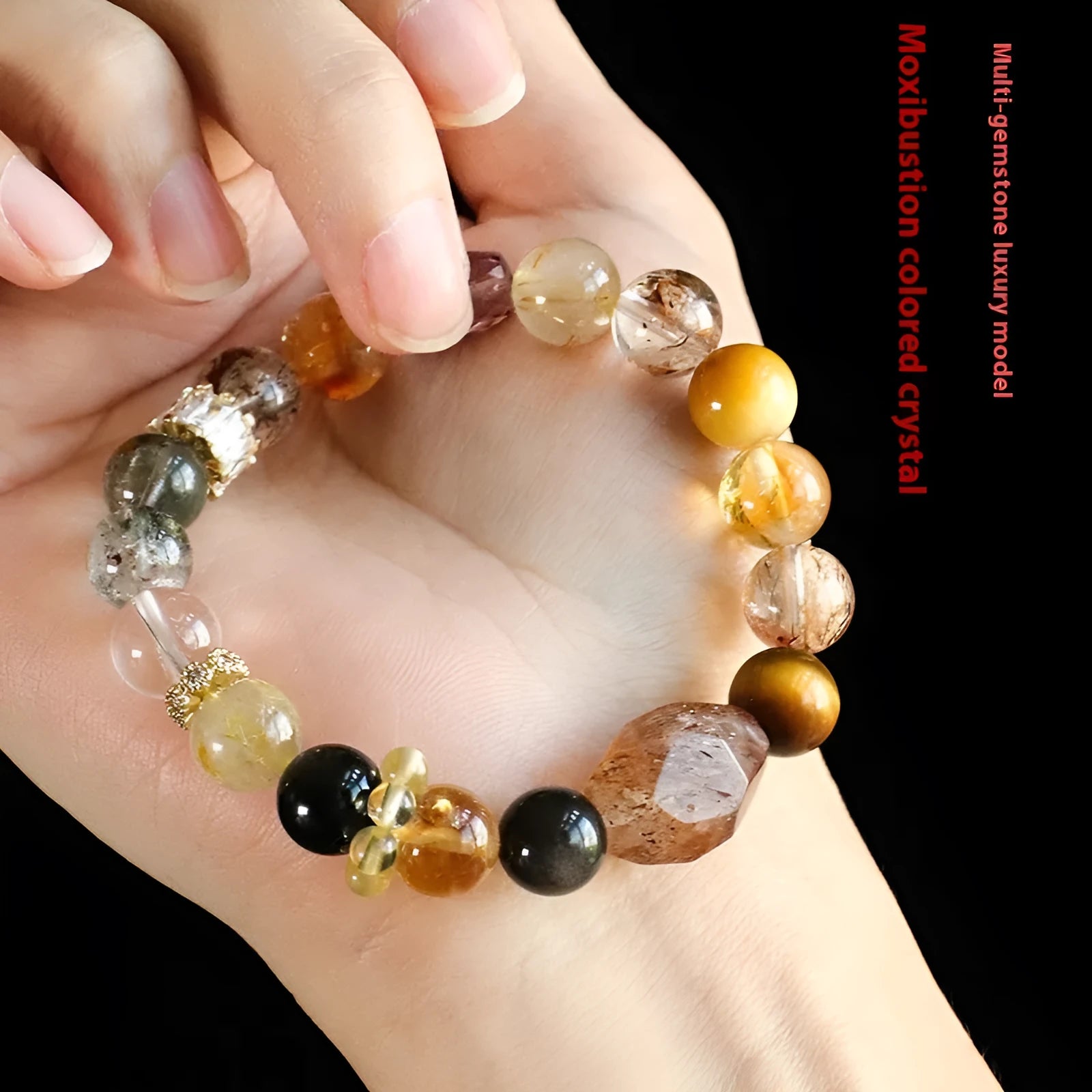 Close-up of a women's black and gold bracelet with natural Super Seven Duobao crystal beads.