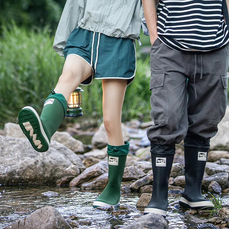 A pair of solid-colour high-tube PVC rain boots with a low heel on a plain background.
