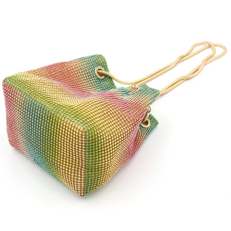 Colourful rainbow rhinestone bucket bag with a single shoulder strap.