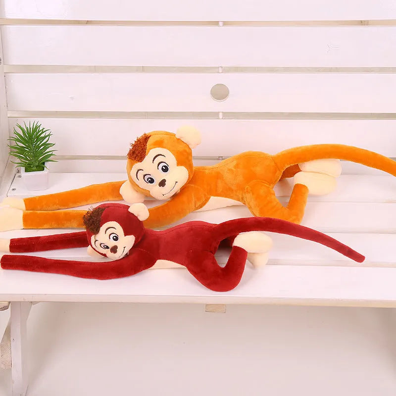 Long-arm pink plush monkey toy hanging from a curtain as home decoration.