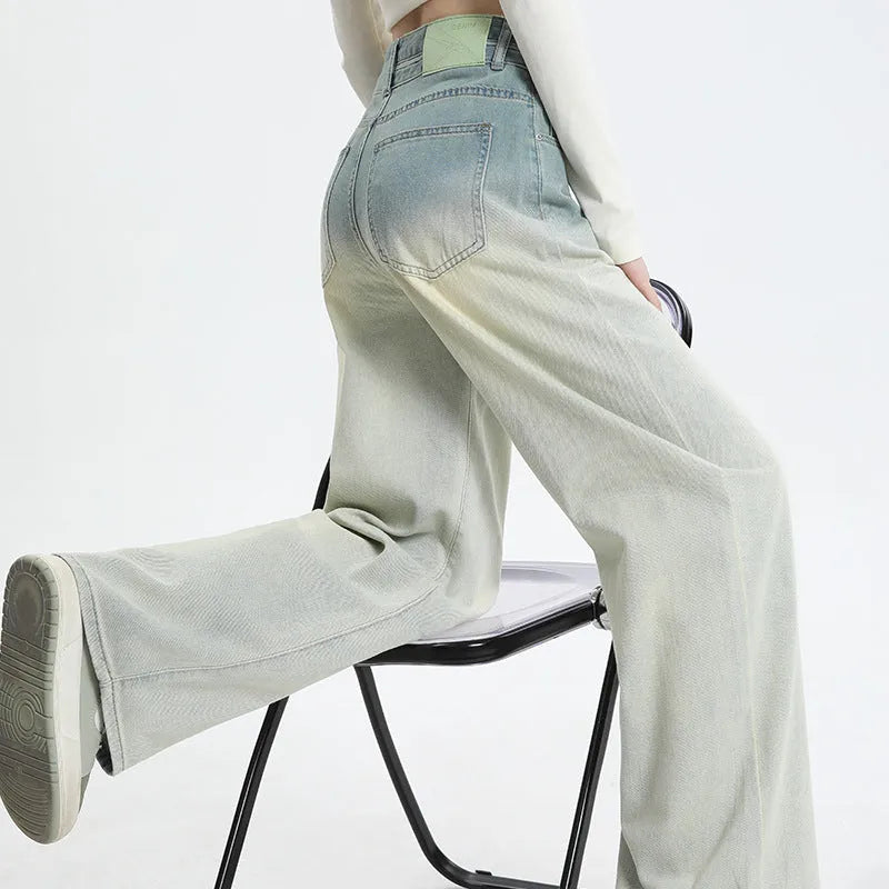 Gradient blue straight-leg denim trousers for women on a hanger, showing the wide-leg cut and colour fade.