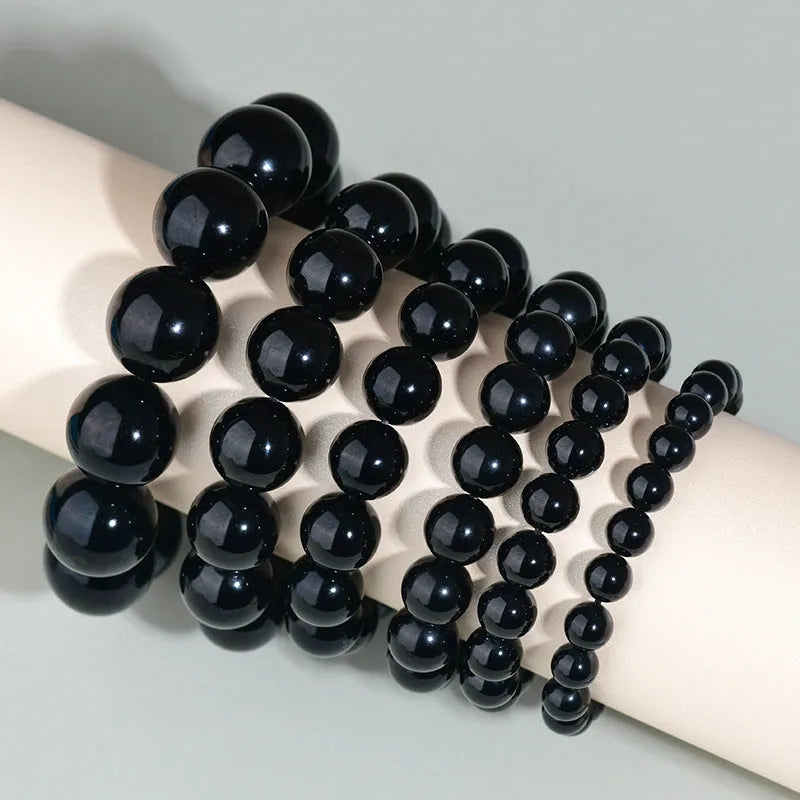 Hand-woven obsidian bracelet with round crystal beads in black stone variations including rainbow eye obsidian