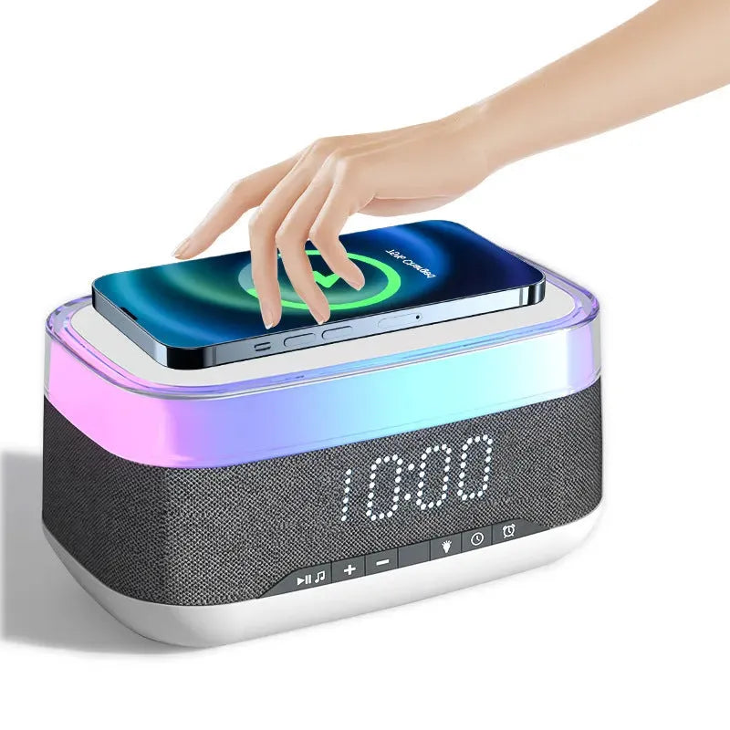 White multifunctional alarm clock with Bluetooth speaker and wireless charging pad on a bedside table.