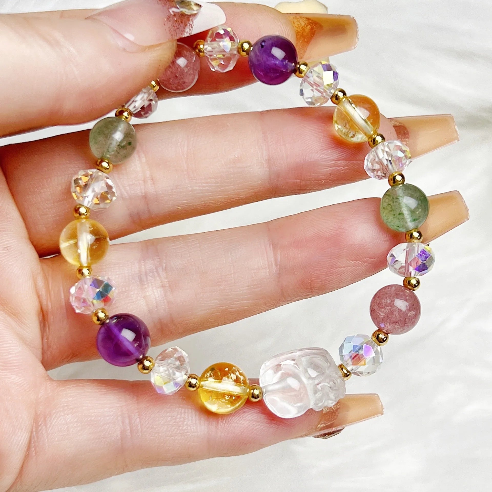 Close-up of a women's crystal bracelet with a detailed nine-tailed fox charm and colour faceted stones.