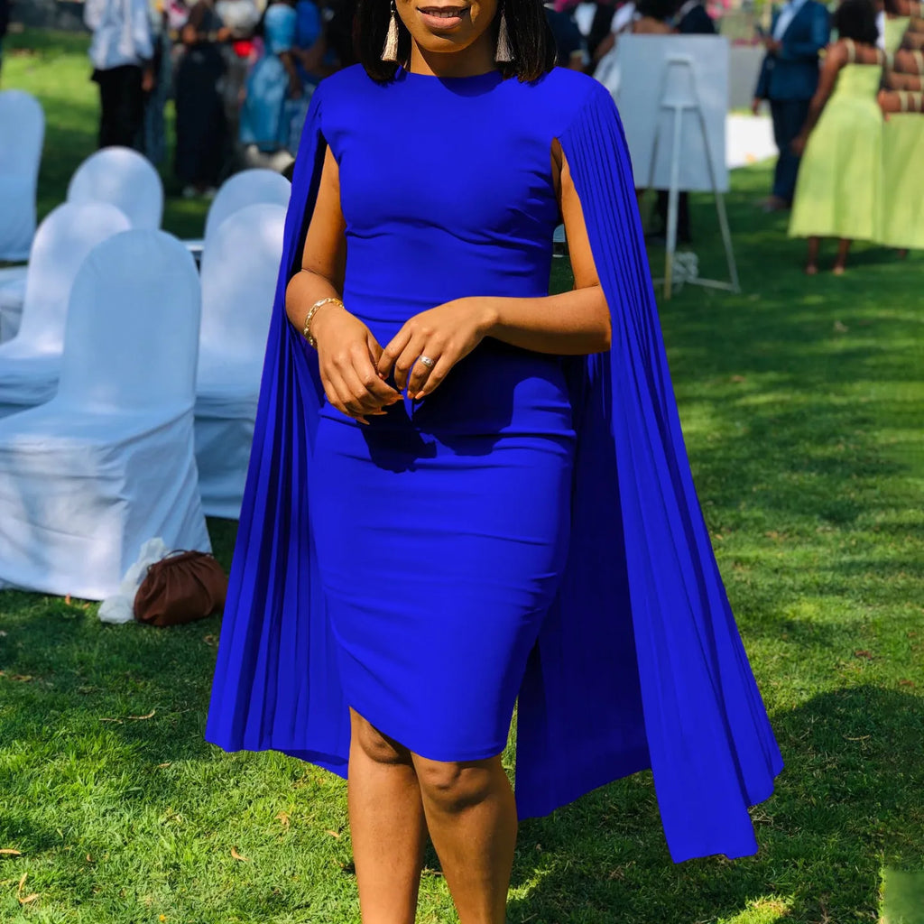 A woman wearing a long sleeve, high-waisted pleated evening gown in a formal setting.