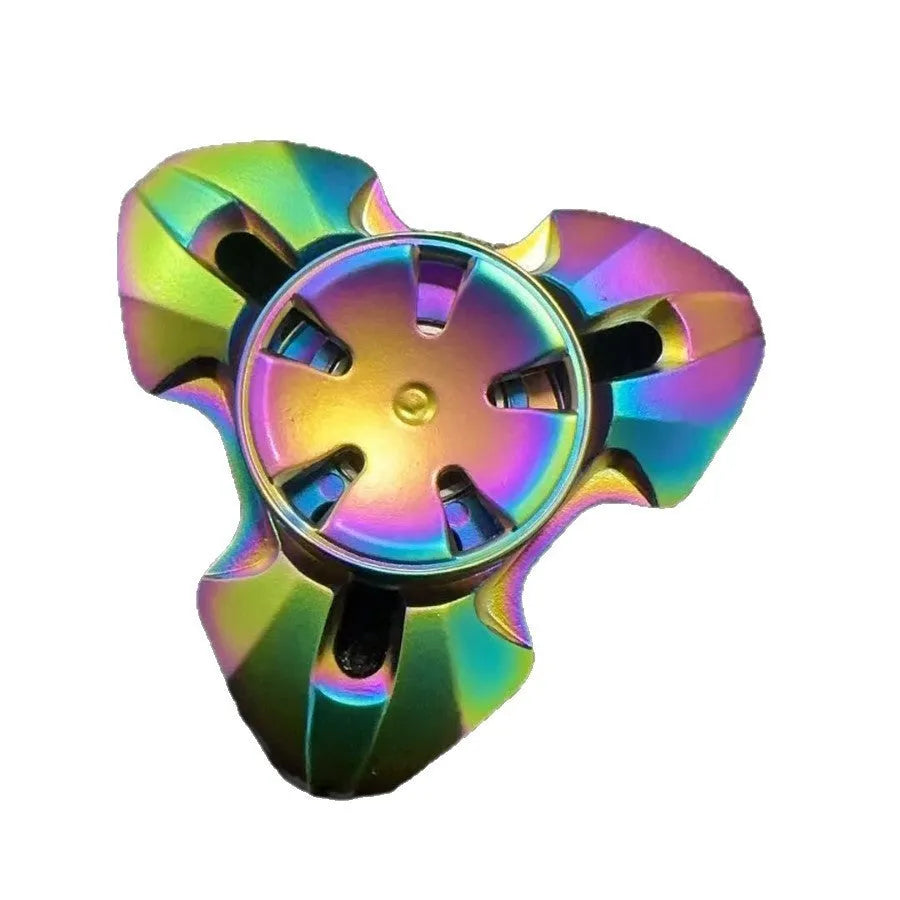 Alloy metal fingertip gyro decompression toy in gun metal colour, spinning on a surface.