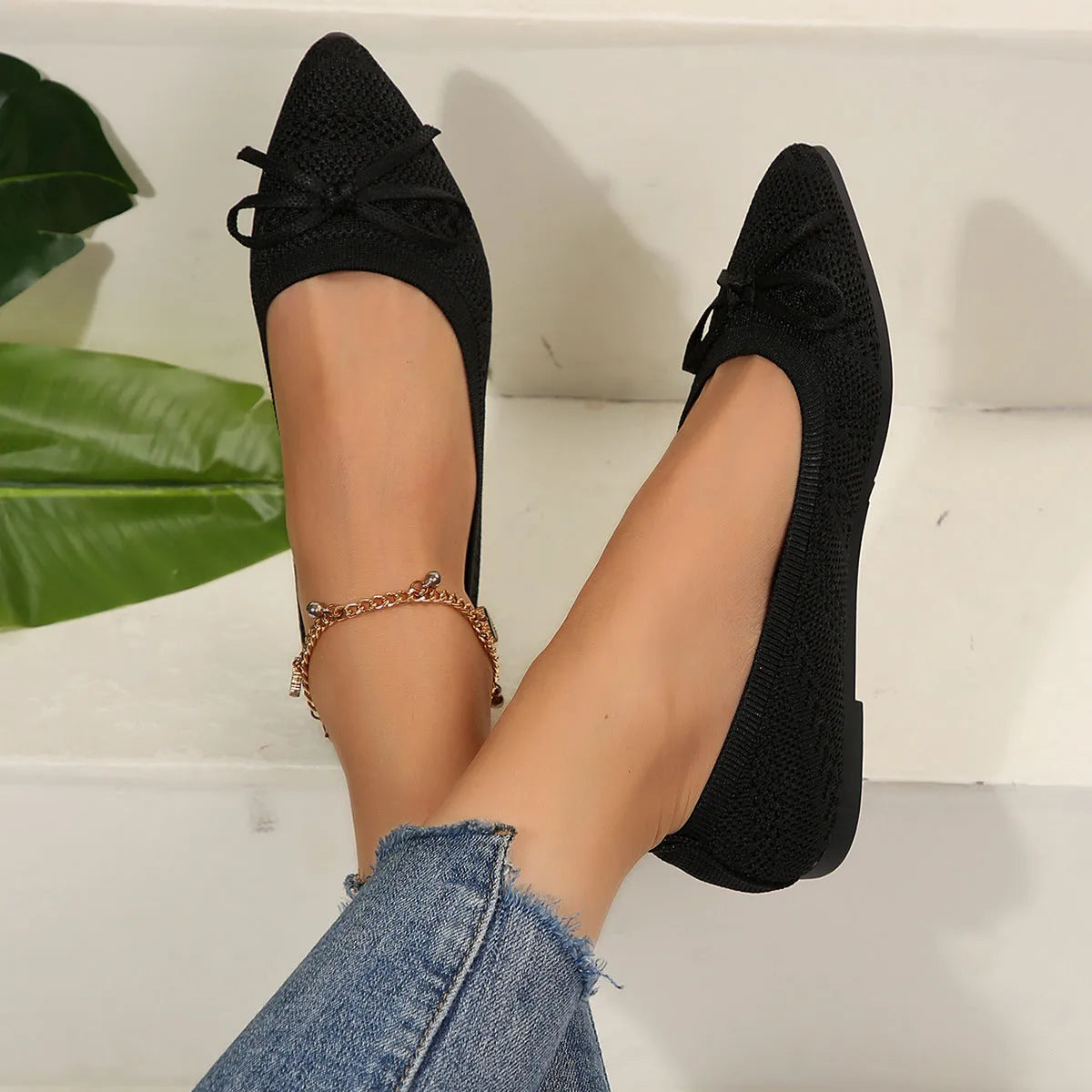Women's blue knitted flat loafers with a bow and pointed toe on a rubber sole.