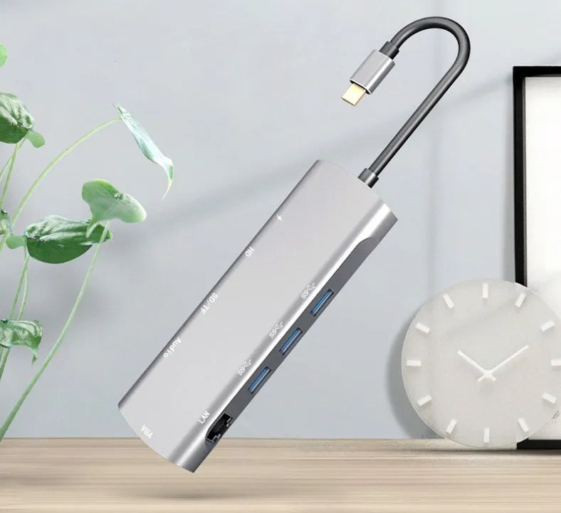 Grey aluminium USB-C docking station showing HDMI, VGA, USB 3.0, and card reader ports.