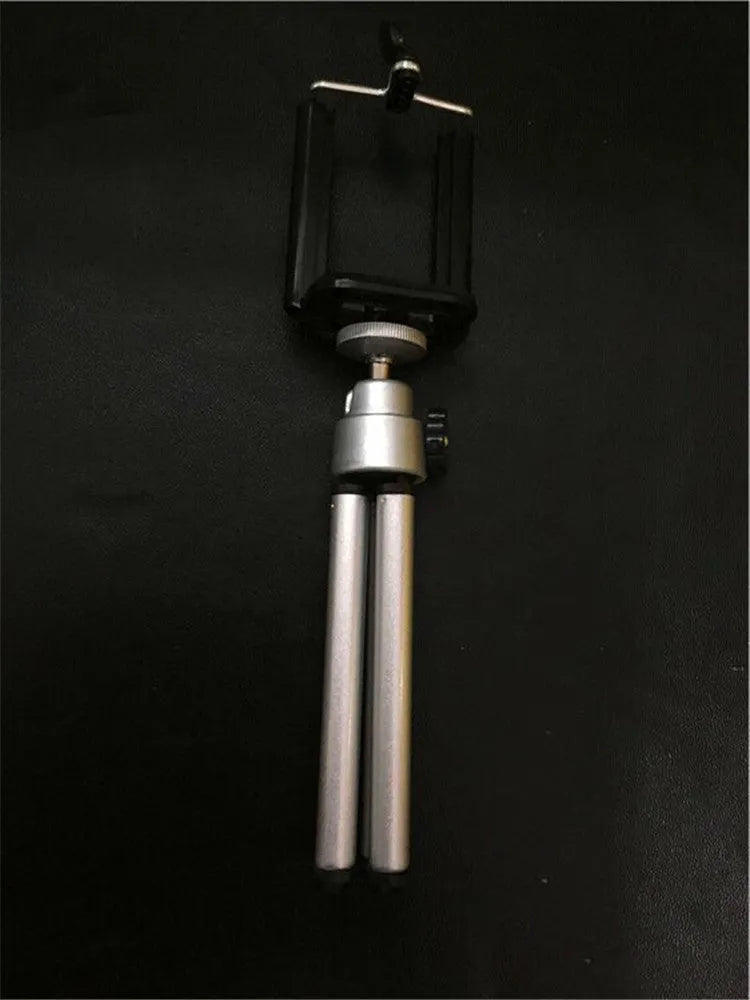 Black and silver desktop phone holder with a two-section adjustable bracket on a wooden desk.