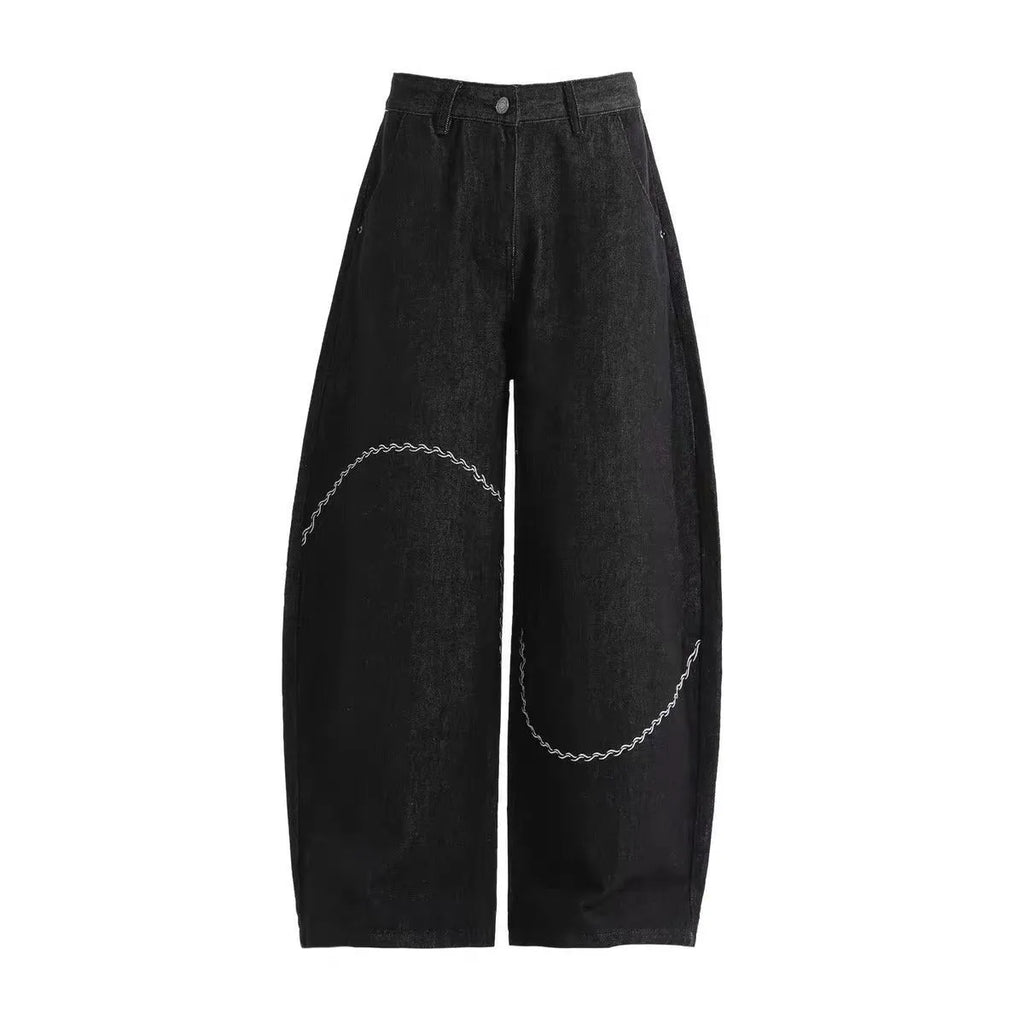 Black straight-leg denim trousers laid flat, showing zip fly and mid-waist design.