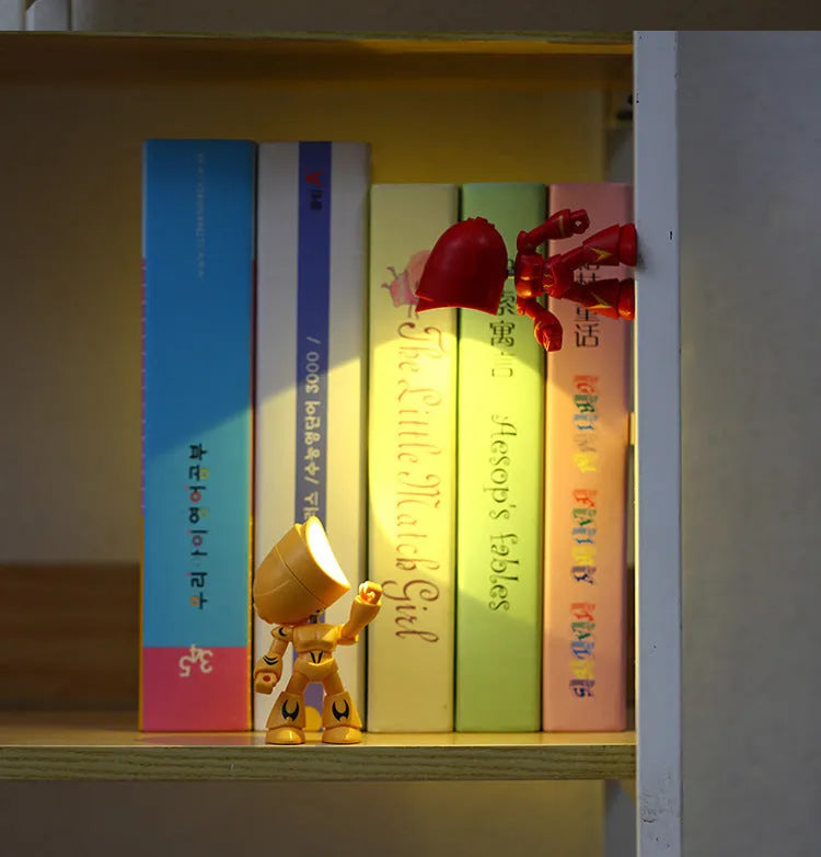 Mini LED hero robot night light with warm glow, adjustable arms, and 360-degree rotating head on a wooden shelf