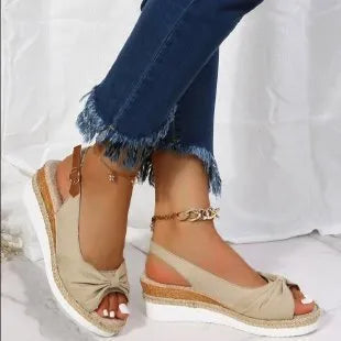 Peep toe platform sandal with one-line buckle strap, cloth upper, rubber sole, shown in black.