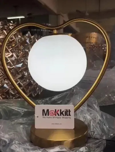 Heart shaped decorative LED lamp providing a warm glow on a table.