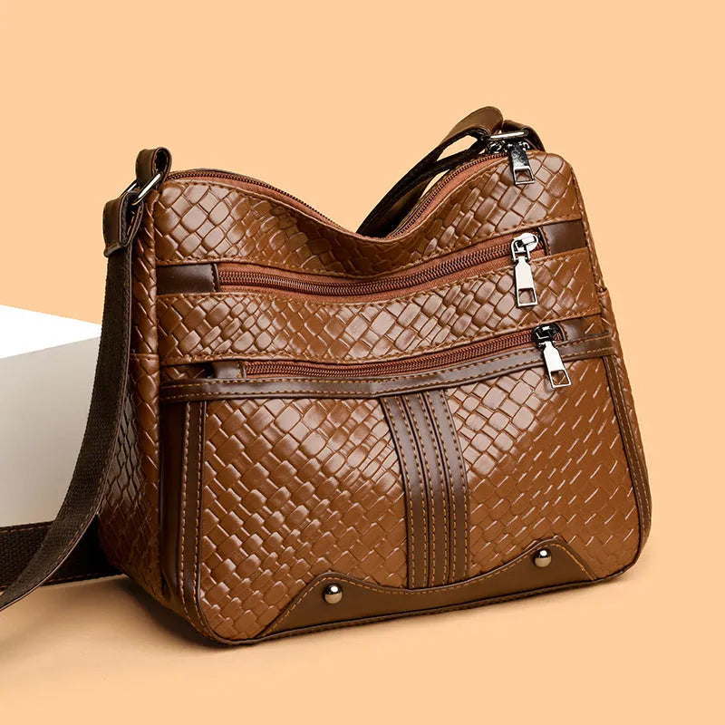 Brown PU leather single shoulder messenger bag with woven strap and multiple compartments.