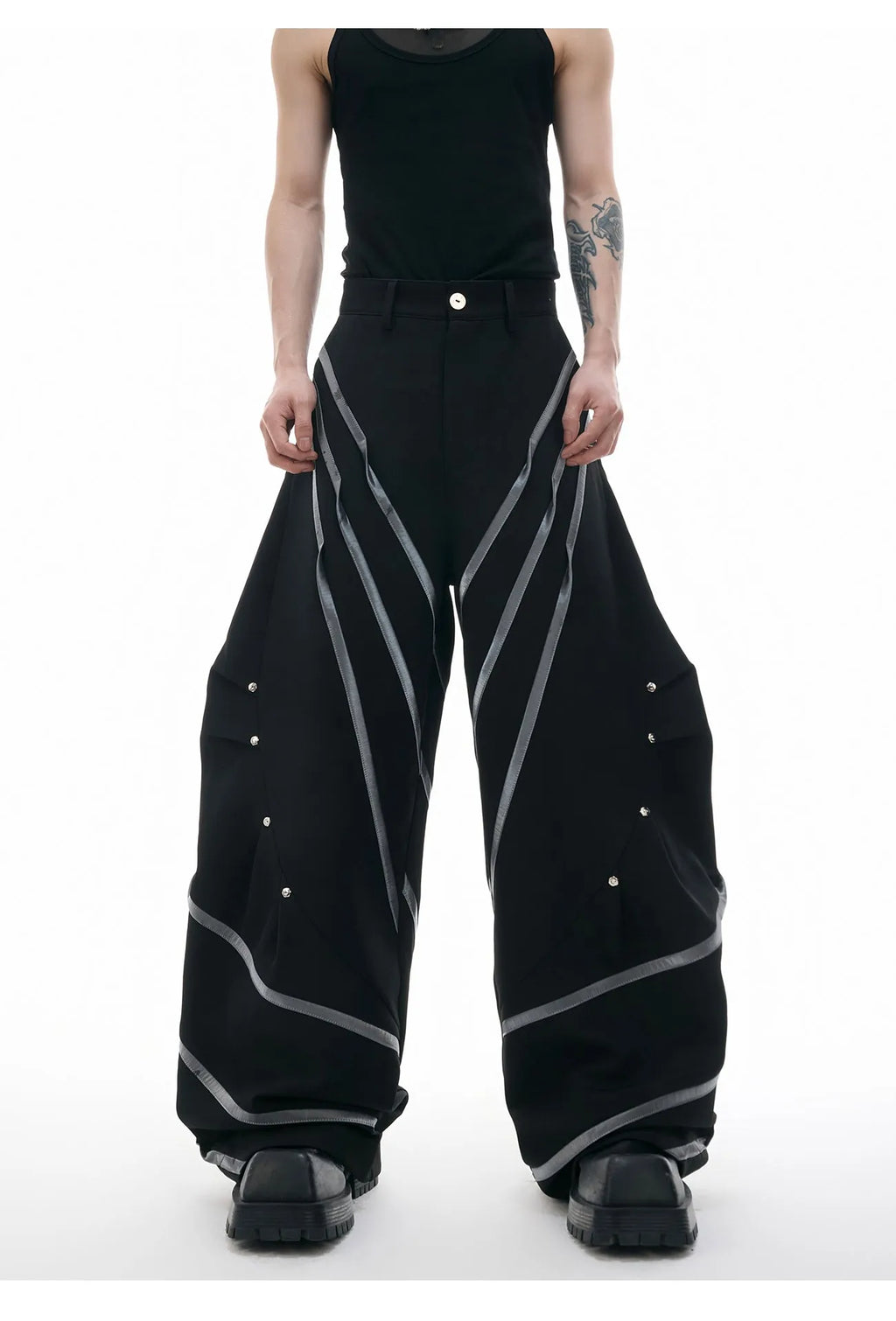 Men's black trousers with metal rivet stripes and pleated detail on the leg.