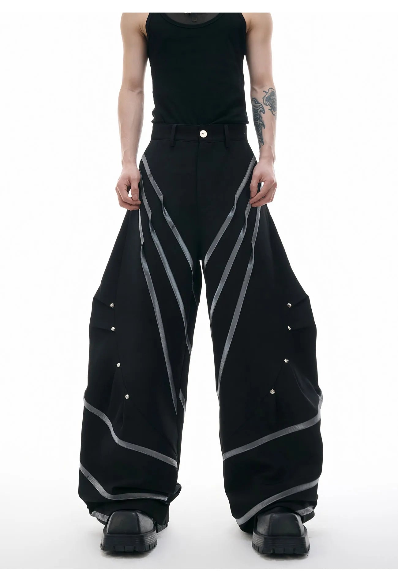 Men's black trousers with metal rivet stripes and pleated detail on the leg.