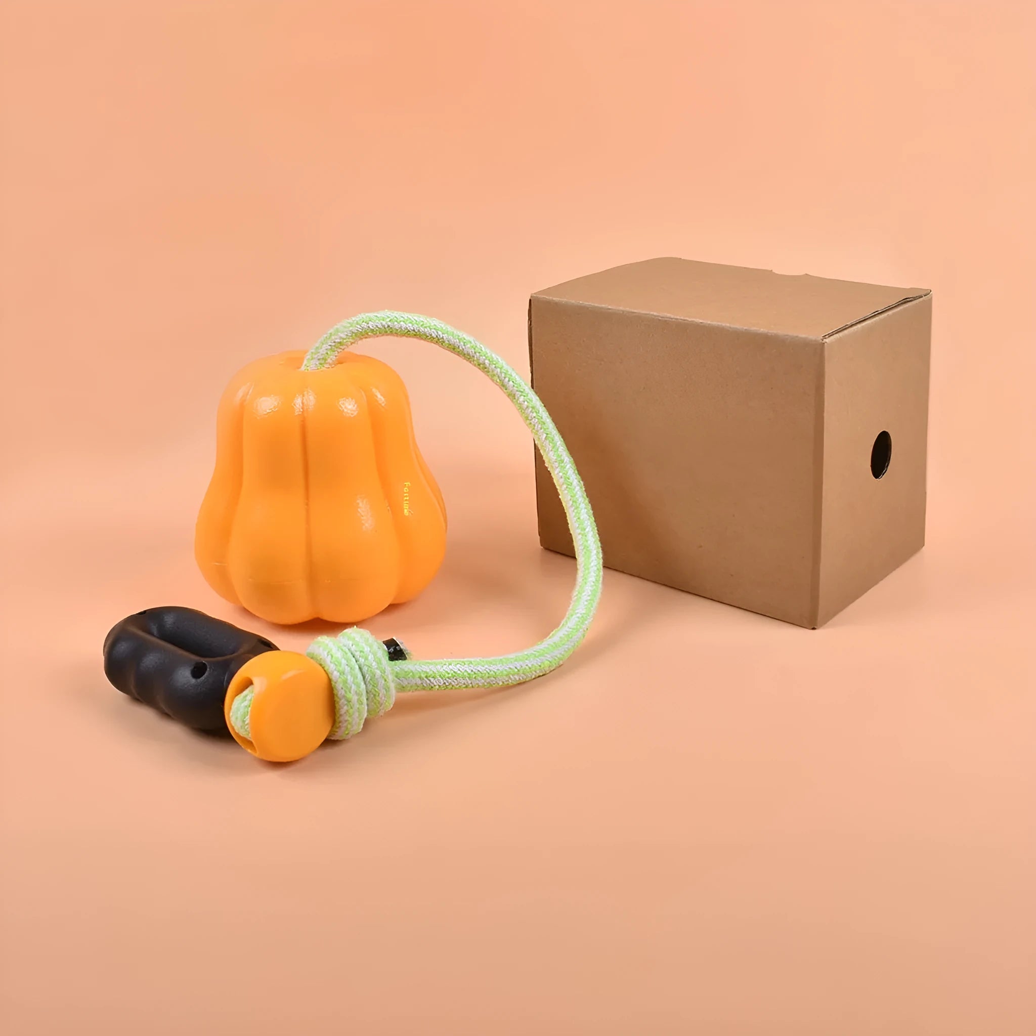 Pumpkin orange plastic dog chew toy with a woven rope handle for fetch.