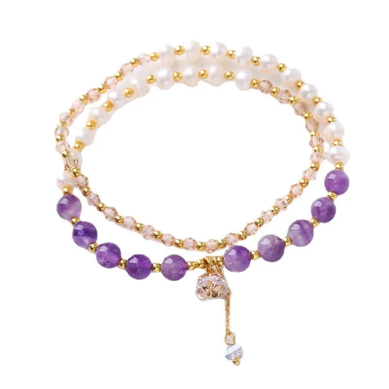 Handmade women's double ring bracelet with freshwater pearls and a central amethyst crystal.