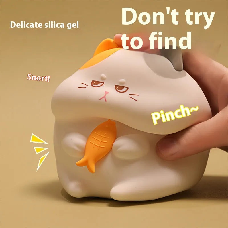 Small greedy cat cartoon desktop night light with yellow fin tuna design on a desk.