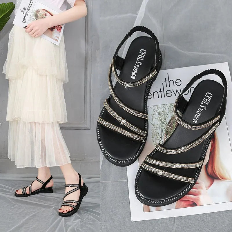 Gold women's flat sandals with sequin decoration and an elastic band, shown on a white background.