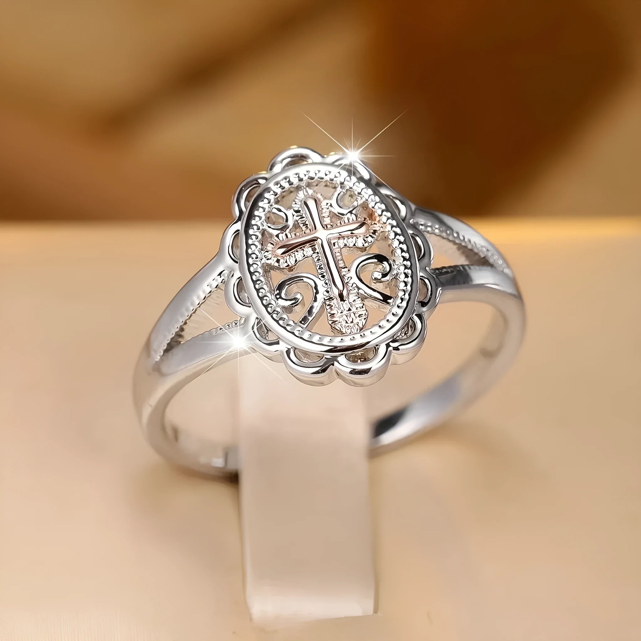 Silver cross and lace patterned alloy ring for women on a white background.