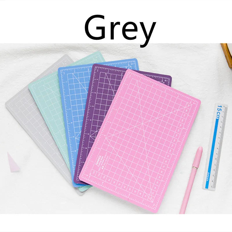 Art pen knife cutting board set in blue, showing plastic backing board with ruler, metal blade, and sharpener.