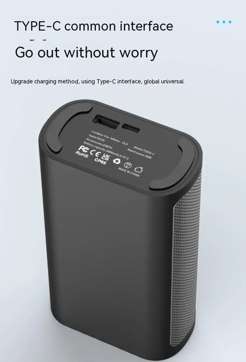 Black handheld wireless digital tyre inflator with LCD screen, LED light and multiple nozzle attachments on a table.