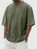 Man wearing a loose-fit, distressed army green pullover T-shirt with half sleeves.