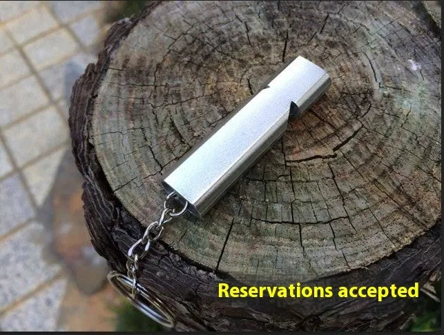 Silver and gold coloured aluminium alloy double-hole outdoor survival whistle with keychain.