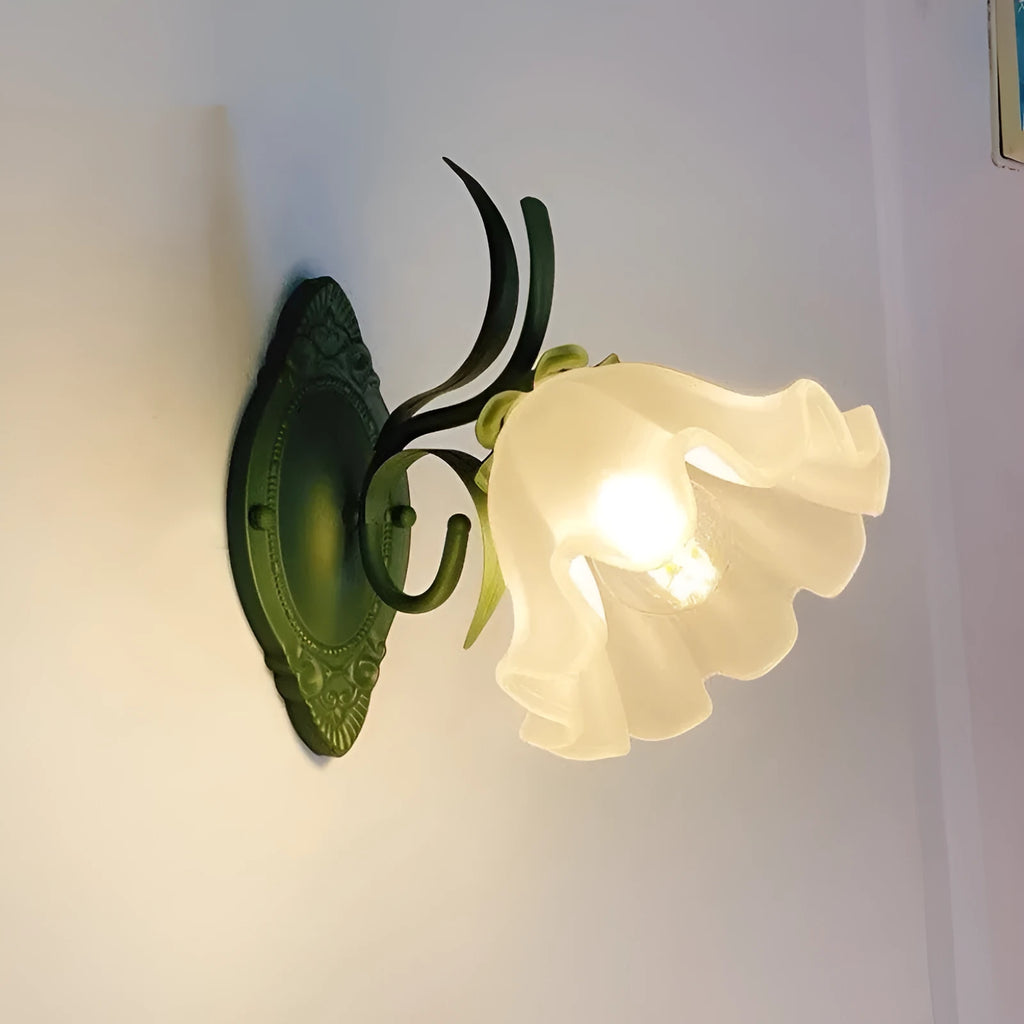 Green pastoral style flower-shaped wall lamp with a glass shade and integrated LED light.