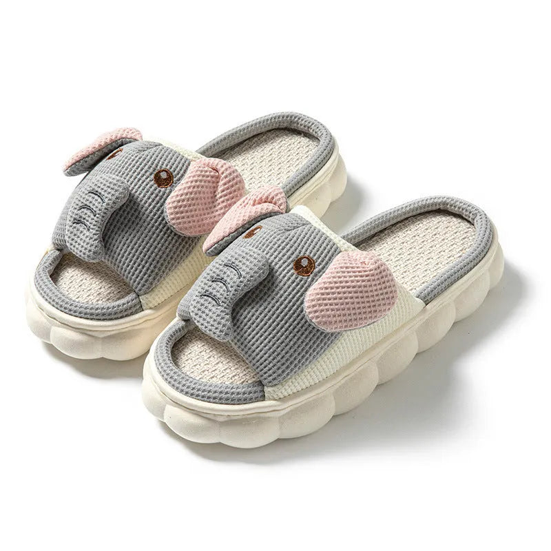 A pair of elephant grey open-toe linen slippers for couples on a plain background.