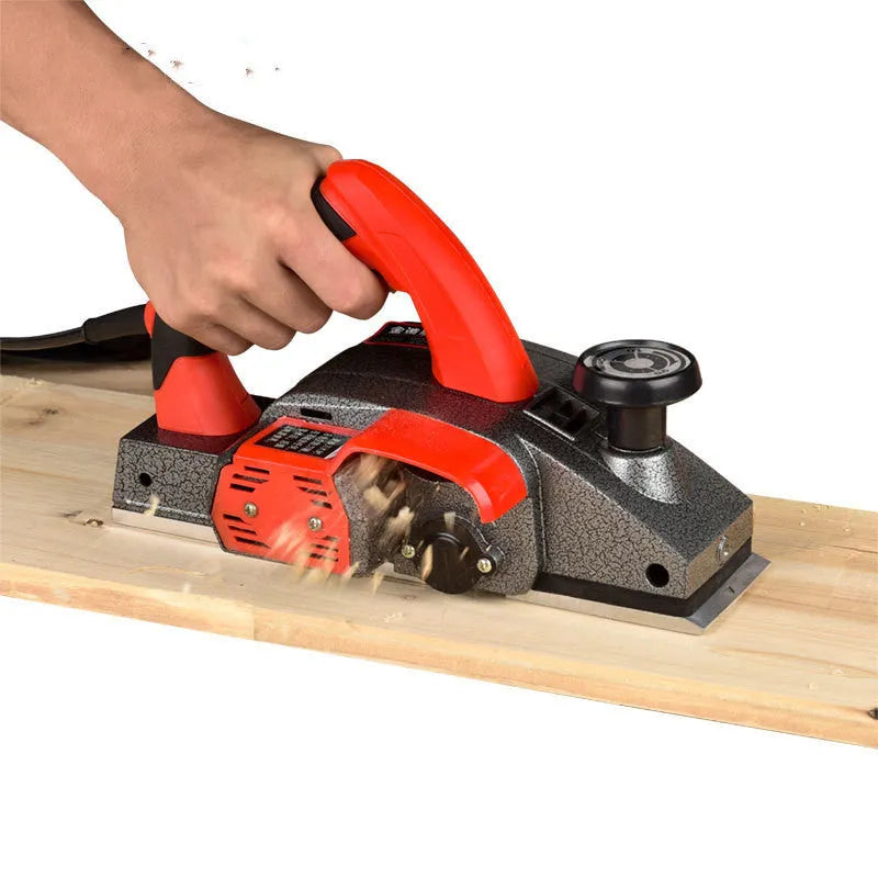 Red aluminium electric wood planer with 82mm width on workbench